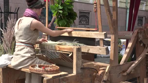 Kvinnan väva mattan mattan med retro hantverk vävstol i utomhus fair. 4k — Stockvideo