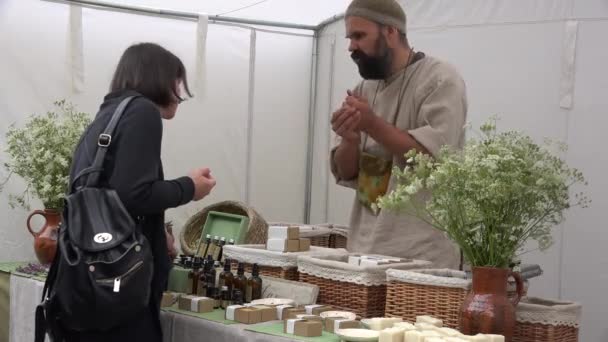 Erborista venditore vendere profumo naturale, aroma e saponi in fiera annuale. 4K — Video Stock