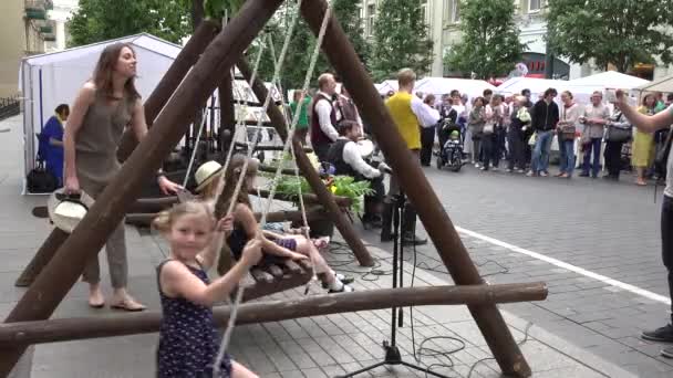 Mädchen schaukeln auf hölzerner selbstgebastelter Schaukel in der Stadtstraße. 4k — Stockvideo