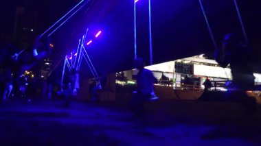vatandaş insanlar şehirde neon ışık ip salıncak geceleri rulo. 4k