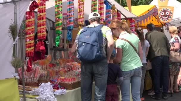 Familia comprar dulces y caramelos vendidos en la feria del mercado callejero. 4K — Vídeo de stock