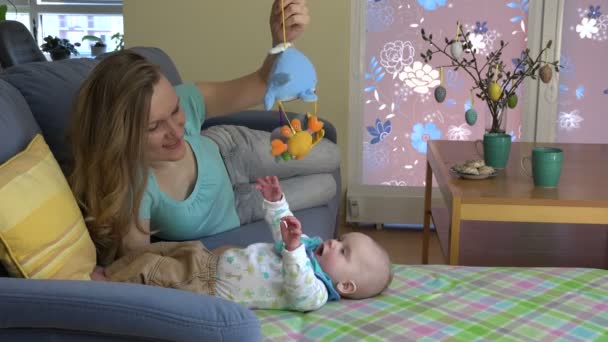 Madre y niña curiosa jugar con el juguete en el sofá. 4K — Vídeo de stock