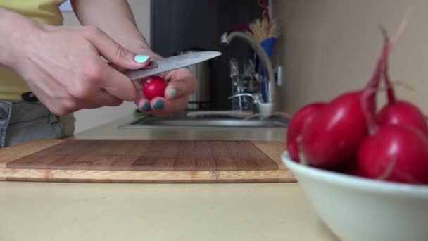 Руки нарізають овочі редьки на ріжучій дошці для салату. 4-кілометровий — стокове відео
