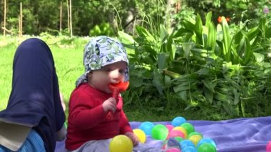 Anne, kitap okumak ve bebek yeşil park içinde birlikte oynamak. 4k