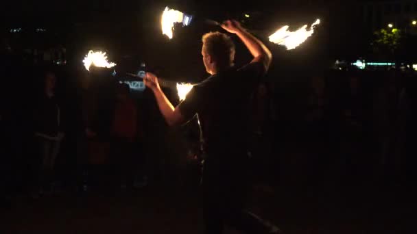 Amatoriale uomo giocoliere bruciando bastoni di fuoco di fronte al pubblico cittadino. 4K — Video Stock