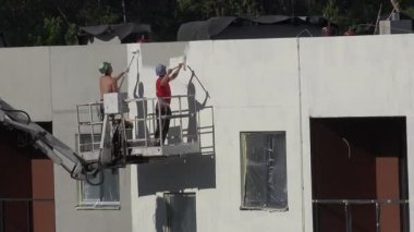 İşçiler erkekler beyaz yeni yapı modern ev duvar boyası. 4k