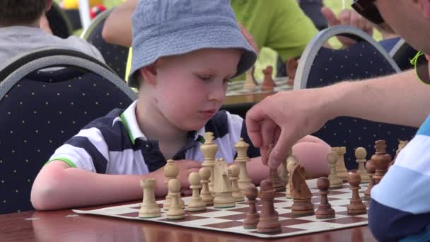 年轻聪明的男孩想和国际象棋棋子朝着免费锦标赛。4 k — 图库视频影像