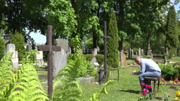 Un homme seul prie près de la tombe d'un membre mort de sa famille et s'en va. 4K — Video