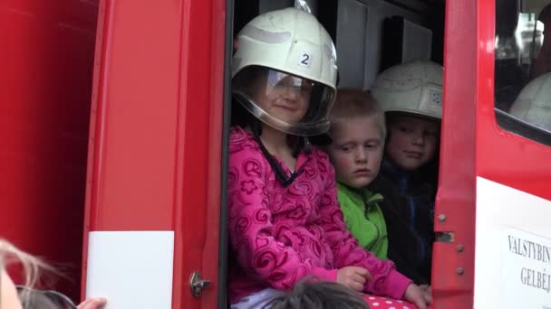 Niños felices con cascos de bombero en camión de bomberos. 4K — Vídeo de stock