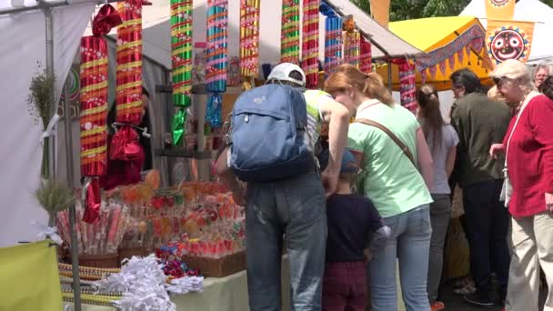 Люди покупают цветной сахар сладкий на городском рынке. 4K — стоковое видео