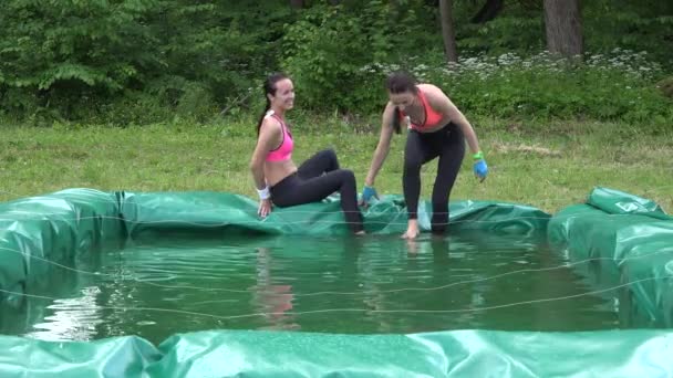 Haughty woman try to overcome hurdles over water pool and remain dry. 4K — Stock Video