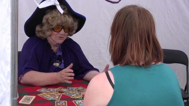 Adivino predecir el futuro con tarjeta del tarot a la mujer al aire libre. 4K — Vídeo de stock