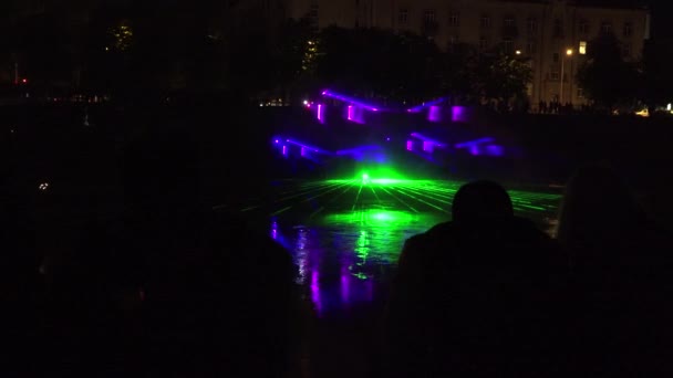 Mensen kijken naar Laser video projecties lichteffecten op de rivier 's nachts. 4k — Stockvideo