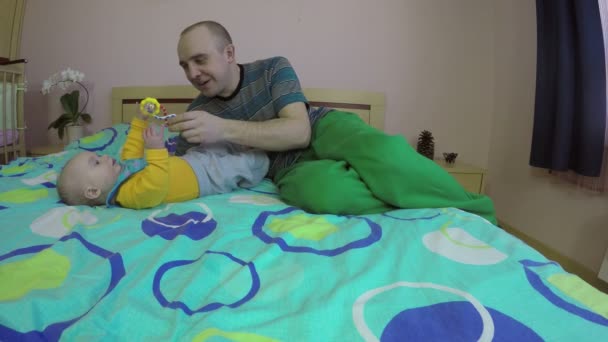 Pai amoroso dar bebê filha brinquedo. Homem conversa com recém-nascido. 4K — Vídeo de Stock