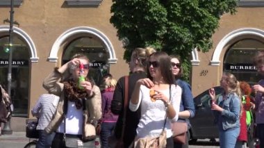 Gençler büyük uluslararası geçit töreninde sabun köpükleri üflüyorlar. 4K