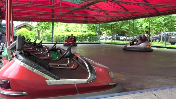 孩子与父母乘坐五颜六色的保险杠车在游戏公园。4k — 图库视频影像