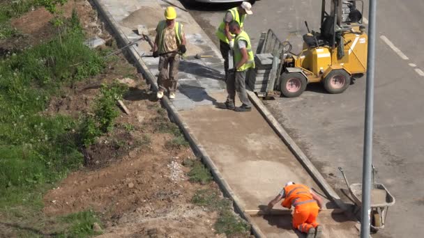 Trabalhadores areia nível e pavimentar colocar telhas de lado. 4K — Vídeo de Stock