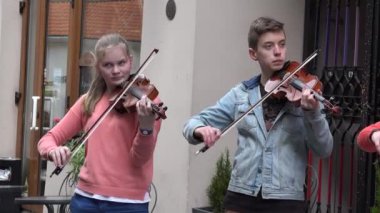 Genç müzisyenler grubu serbest sokak etkinliğinde keman çalıyor. 4K