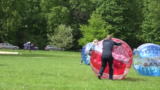 Förälder push barn i Zorb Bubble Ball på Park Grass. 4K — Stockvideo