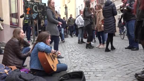 Aranyos lány ülni utcai járdán játszani gitár énekelni. 4k — Stock videók