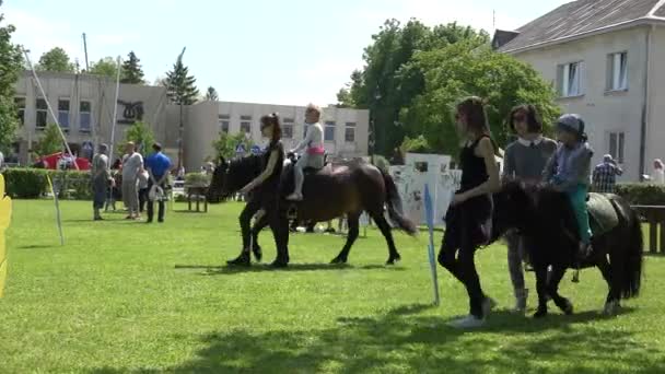 Chica feliz paseo a caballo criador con manipuladores en el parque verde. 4K — Vídeos de Stock