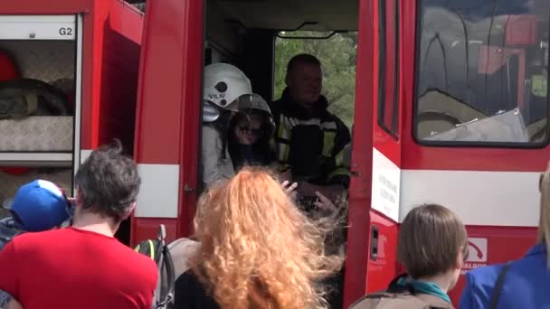 Children measure firefighter helmet inside fireman emergency truck. 4K — Stock Video