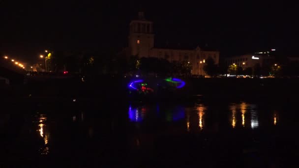 Граждане ночью наблюдают за эффектами лазерной проекции на реке. 4K — стоковое видео