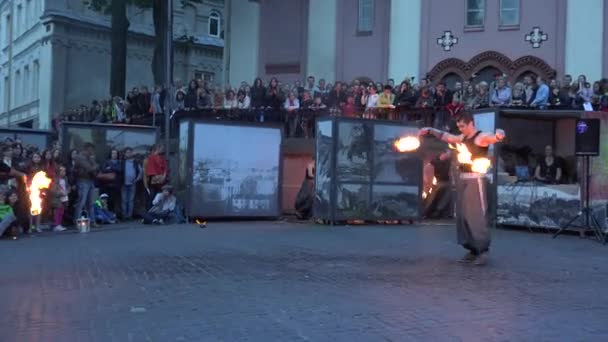 Kobieta i chłopiec tańczą z pochodnią wentylatora na placu dla ludzi. 4K — Wideo stockowe