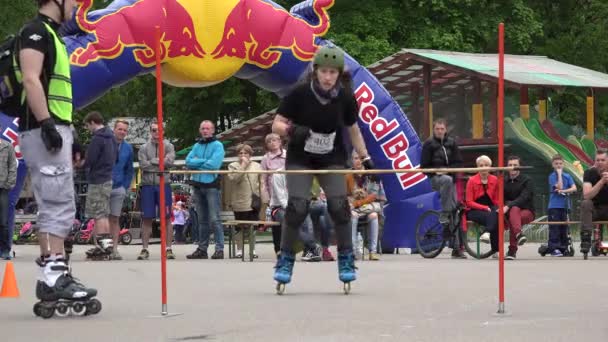 Joven patinadora deportista saltar por encima de la barra alta en la competencia. 4K — Vídeo de stock