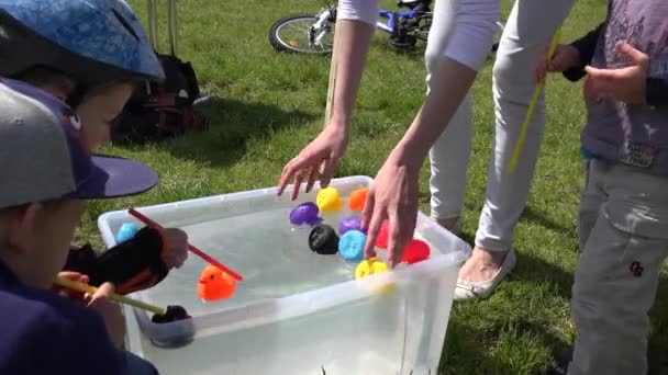 Saman lı çocuklar plastik su havuzunda ördek yarışı oynarlar. 4k — Stok video
