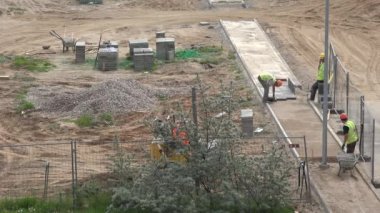 İşçiler kaldırım için temel hazırlar ve kaldırıma fayans sererler. 4K