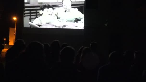 Mensen kijken stomme film van Charlie Chaplin cinema 's nachts. 4k — Stockvideo