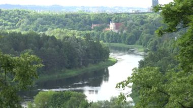 Manastır binaları ve Neris nehri ormanlar arasında akıyor. 4k