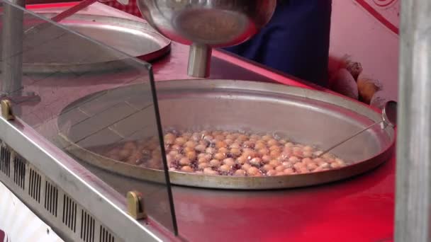 Donuts doces assar em prato especial com óleo quente e padeiro mão mistura. 4K — Vídeo de Stock