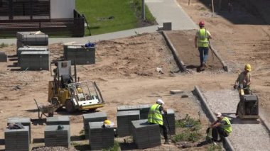 İşçiler takımız kaldırım döşemesi yeni düz ev yakınındaki Döşe. 4k