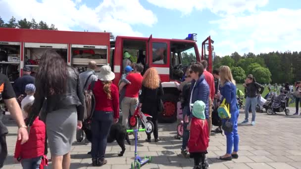 Родители с детьми вокруг военного пожарного грузовика. 4K — стоковое видео