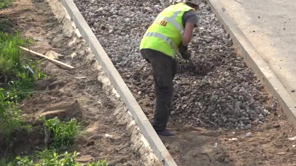 Escombros nivel trabajador en nuevo lugar acera pavimento. 4K — Vídeo de stock