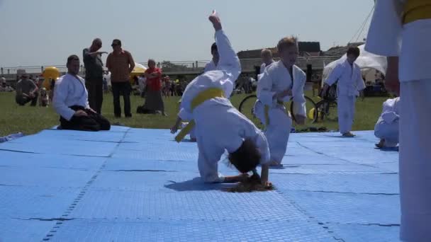 I bambini fanno l'esercizio di capriola sotto supervisione di allenatore di judo. 4K — Video Stock