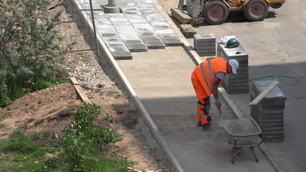 Homem no trabalho fazendo calçada no canteiro de obras. 4K — Vídeo de Stock