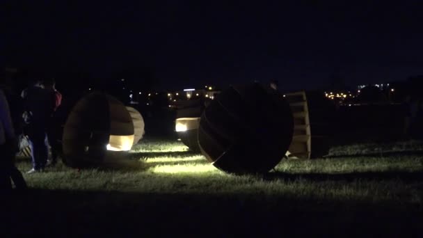 Menschen zwischen handgefertigten Pappkugeln formen beleuchtete Dekorationen. 4k — Stockvideo
