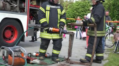 İtfaiyeciler gösteri metal kesme insanlar için parkta toplanan. 4k