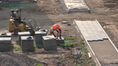 Çalışan adam taşımak ve fayans yeni kaldırım kaldırımda yatıyordu. 4k