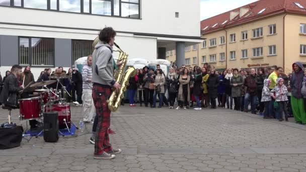 Jongen met blaasinstrument uitvoeren menigte van mensen op straat. 4k — Stockvideo