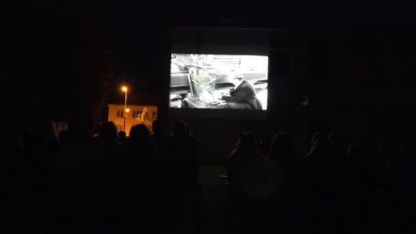 Ludzie oglądają plener pokaz starych filmów kinowych. 4k — Wideo stockowe