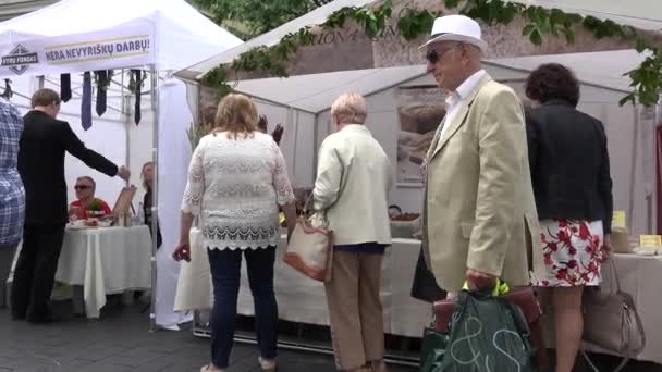 Pan natural y otros productos vendidos y personas en la feria de bazar. 4K — Vídeo de stock