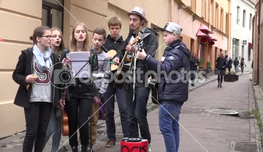 Gençler grup gitar çalıp şarkı eski şehir sokak. 4k