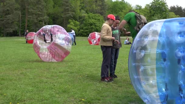 Los niños pagan dinero por la recreación activa en bolas zorb. 4K — Vídeos de Stock