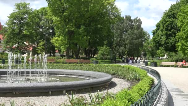 Moderna fuente de subida de agua y la gente recrea en el parque. 4K — Vídeo de stock