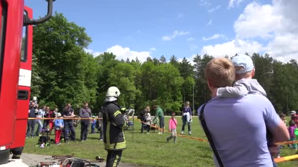 Rodzice z dziećmi Zapraszamy strażak strzelać z węża z wodą. 4k — Wideo stockowe