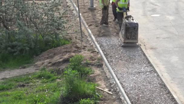 Trabajador con compactador de placa vibratoria antes del pavimento. 4K — Vídeo de stock